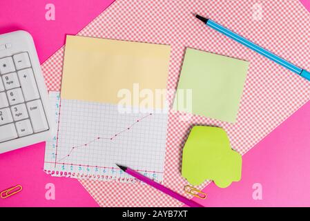 Attrezzature per la scrittura e computer più carta matematica posta su uno sfondo colorato. Stazionario, libro di matematica vicino agli attrezzi di d Foto Stock