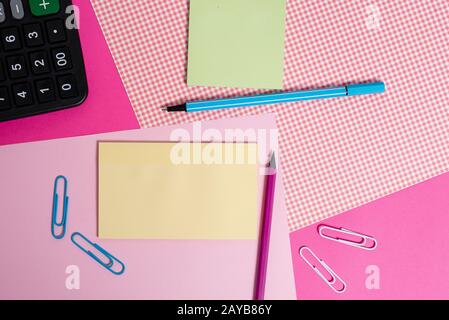 Carte stazionarie e notazioni posizionate sopra lo sfondo colorato. Attrezzature per la scrittura con fogli di appunti su un tavolo semplice. Wa artistico Foto Stock