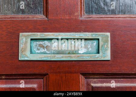 Vecchia mailbox retrò sulle porte di legno. Foro sulle porte di legno per posta. Concetto di comunicazione con la mailbox sulle vecchie porte. Foto Stock