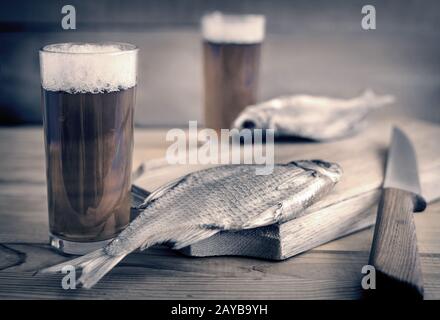 Due bicchieri di birra e pesce essiccati . Foto Stock