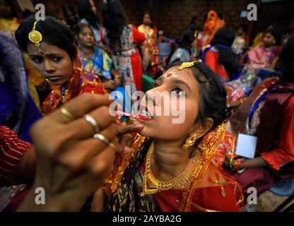 Calcutta, India. 14th Feb, 2020. Una sposa si prepara per la cerimonia del matrimonio. Una ONG chiamata ''Aloy Phera'' ha organizzato una cerimonia di matrimonio di 170 coppie di diverse religioni in kolkata il giorno di San Valentino per diffondere il messaggio di amore e armonia sociale. In questo evento hanno preso parte coppie di varie comunità arretrate prive di un sostegno finanziario di base nella loro famiglia. Credit: Avishek Das/Sopa Images/Zuma Wire/Alamy Live News Foto Stock