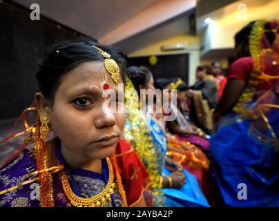 Calcutta, India. 14th Feb, 2020. Una sposa si prepara per la cerimonia del matrimonio. Una ONG chiamata ''Aloy Phera'' ha organizzato una cerimonia di matrimonio di 170 coppie di diverse religioni in kolkata il giorno di San Valentino per diffondere il messaggio di amore e armonia sociale. In questo evento hanno preso parte coppie di varie comunità arretrate prive di un sostegno finanziario di base nella loro famiglia. Credit: Avishek Das/Sopa Images/Zuma Wire/Alamy Live News Foto Stock