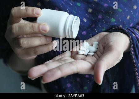 Primo piano di pillole sul palmo della mano delle donne Foto Stock