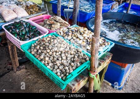 Thai bazaar con varietà di carni le vongole, cozze e crostacei in cesti e serbatoi Foto Stock