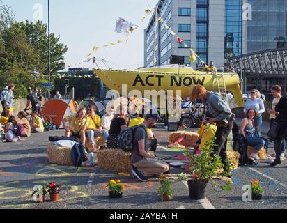 persone sedute intorno alla barca e tende che bloccano la strada bridgewater place a leeds durante una protesta di ribellione estinzione Foto Stock