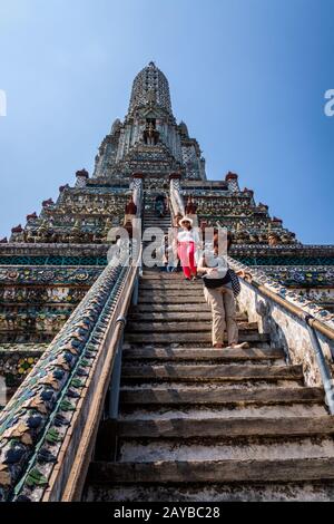 I turisti salendo e scendendo su scale ripide di Wat Arun tempio Foto Stock