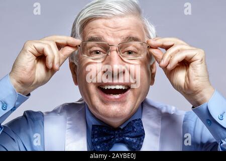 Primo piano ritratto di divertente sorridente allegro anziano uomo d'affari impiegato con occhiali Foto Stock