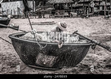 Rete di fissaggio del pescatore seduta in barca Foto Stock