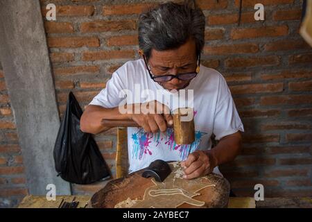 Un uomo sta facendo tradizionale caposaldo giavanese kulit (puppet ombra) di pelle a Yogyakarta, Java, Indonesia. Foto Stock