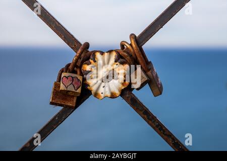 Serrature d'amore su una recinzione arrugginita Foto Stock