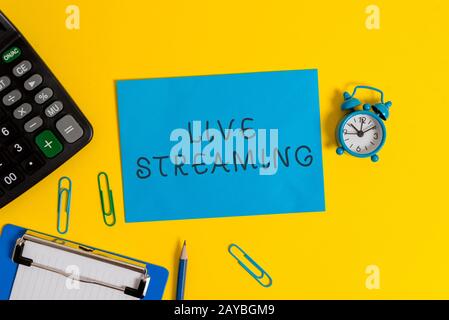 Scrittura di testo Live Streaming. Concetto che significa trasmettere la copertura video in tempo reale di un evento tramite il clip del foglio degli Appunti Internet Foto Stock