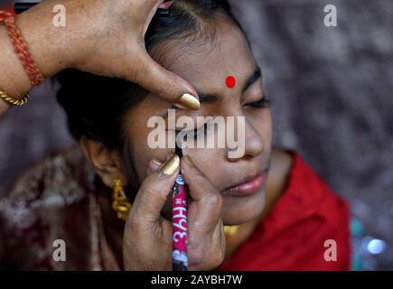 Calcutta, India. 14th Feb, 2020. Una sposa si prepara per la cerimonia del matrimonio. Una ONG chiamata 'Aloy Phera' ha organizzato una cerimonia di matrimonio di 170 coppie di diverse religioni a kolkata il giorno di San Valentino per diffondere il messaggio di amore e armonia sociale. In questo evento hanno preso parte coppie di varie comunità arretrate prive di un sostegno finanziario di base nella loro famiglia. Credit: Sopa Images Limited/Alamy Live News Foto Stock