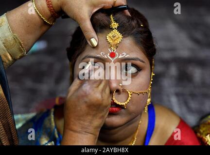 Calcutta, India. 14th Feb, 2020. Una sposa si prepara per la cerimonia del matrimonio. Una ONG chiamata 'Aloy Phera' ha organizzato una cerimonia di matrimonio di 170 coppie di diverse religioni a kolkata il giorno di San Valentino per diffondere il messaggio di amore e armonia sociale. In questo evento hanno preso parte coppie di varie comunità arretrate prive di un sostegno finanziario di base nella loro famiglia. Credit: Sopa Images Limited/Alamy Live News Foto Stock