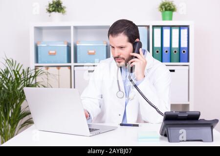 Barbuto medico che lavorava presso il suo ufficio. Business e concetto medico. Foto Stock