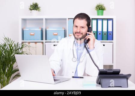 Barbuto medico che lavorava presso il suo ufficio. Business e concetto medico. Foto Stock