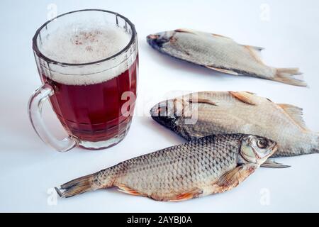 Pesci secchi sul tavolo e un bicchiere di birra Foto Stock