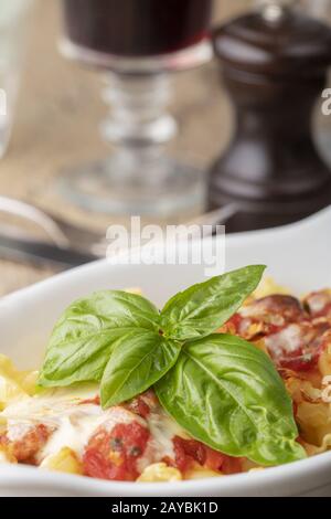 Pasta gratinata su legno con basilico Foto Stock