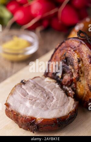 Arrosto di maiale alla griglia su un tagliere Foto Stock