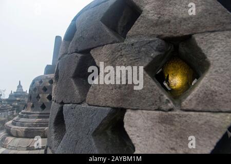 Vista di una statua del Buddha all'interno di uno stupa perforato sulla piattaforma superiore del tempio di Borobudur (sito patrimonio dell'umanità dell'UNESCO, nono secolo), la più grande B. Foto Stock