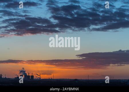 Sonnenuntergang an der Sechs-Seen-Platte in Duisburg mit Blick auf die rauchenden Schlote am Horizont Foto Stock