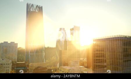 Città skyscrapes con lente flairs al tramonto Foto Stock