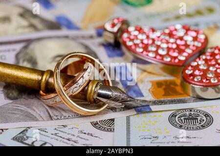 Matrimonio di matrimonio di convenienza anelli dorati su banconote sfondo Foto Stock