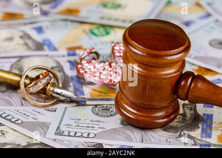 Legge il gavel del giudice di concetto di famiglia sui dollari americani con gli anelli dell'oro di nozze Foto Stock