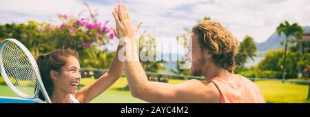 Sport estivo tennis giocatori di divertirsi facendo cinque dopo il gioco. Stile di vita sano vita all'aperto misto doppio banner panorama. Foto Stock