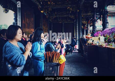 Gruppo di donne cinesi che pregano al tempio cinese Foto Stock
