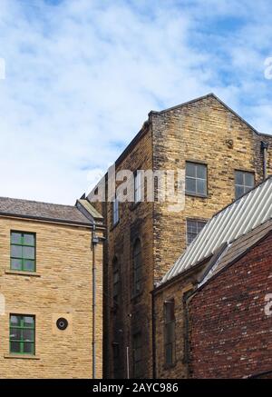 vecchio magazzino in pietra del 19 ° secolo e edifici di fabbrica a bradford west yorkshire contro un cielo blu nuvoloso Foto Stock