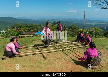 Manggarai donne che eseguono un Tetek Alu, una tradizionale danza di salto con le pole di bambù in un villaggio di Melo nelle colline vicino Labuan Bajo, una città di pesca locate Foto Stock