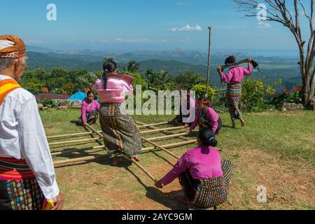 Manggarai donne che eseguono un Tetek Alu, una tradizionale danza di salto con le pole di bambù in un villaggio di Melo nelle colline vicino Labuan Bajo, una città di pesca locate Foto Stock