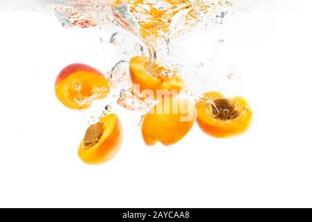 Mazzo di albicocche metà caduto in acqua Foto Stock