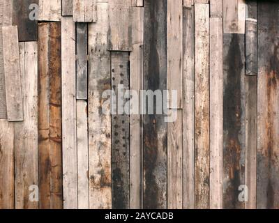 ruvida parete di legno ruvida fatta di vecchie tavole macchiate disaccoppiate riciclate Foto Stock
