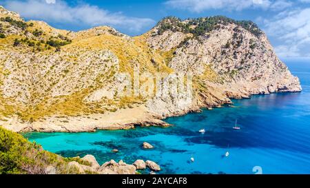 Costa con scogliere, acque turchesi e yacht. Spiaggia Cala Figuera sulla penisola di Formentor, Mallor Foto Stock