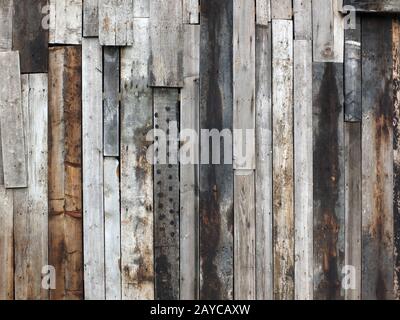 ruvida parete di legno ruvida fatta di vecchie tavole macchiate disaccoppiate riciclate Foto Stock