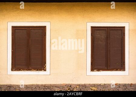 Due finestre in legno con persiane marroni su casa austriaca Foto Stock