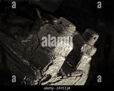 primo piano monocromatico di dadi e bulloni filettati arrugginiti su vecchi macchinari industriali corrosi Foto Stock