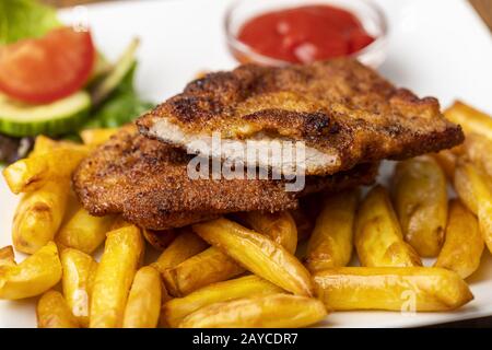 Wiener Schnitzel con patatine fritte sul piatto Foto Stock