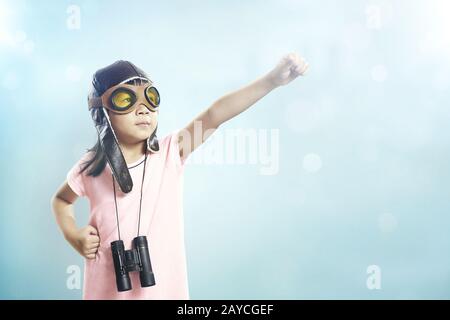 La bambina asiatica indossa occhiali da aviatore e telescopio Foto Stock