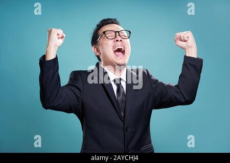 Uomo d'affari eccitato isolato sullo sfondo ciano . Foto Stock