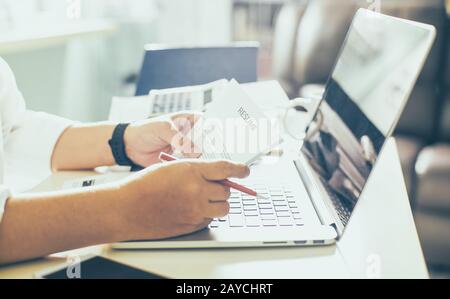 Business uomo rivedere il suo curriculum sulla sua scrivania Foto Stock