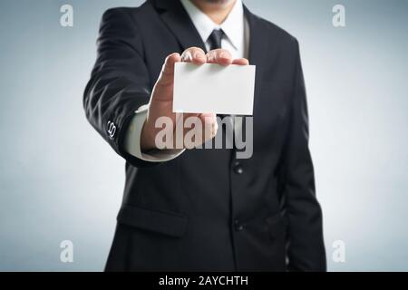 Man mano che mostra business card - closeup shot su sfondo grigio Foto Stock