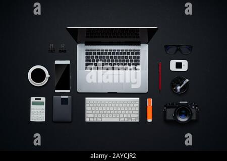 Design grafico e area di lavoro del fotografo. Disposizione piatta e vista dall'alto con materiali di consumo per ufficio e spazio per la copia su sfondo nero. SOHO o Foto Stock