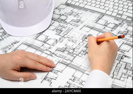 Un uomo che tiene una matita in mano e dipinge disegni architettonici. Foto Stock