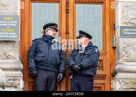 Victoria British Columbia 11 gennaio 2013: Due guardie di sicurezza che si trovano al di fuori dell'ingresso legislativo della Columbia Britannica Foto Stock