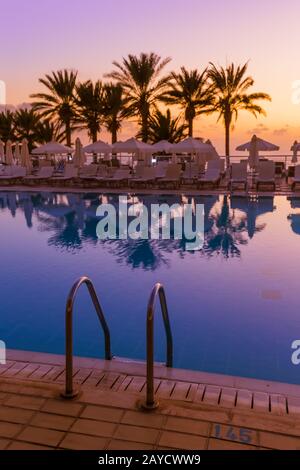 Piscina sull'isola di Cipro al tramonto Foto Stock