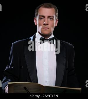 Orchestra in nero Tuxedo in dark studio Foto Stock