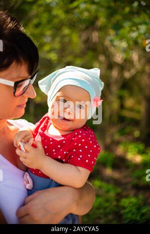 Un anno di età bambina attesa da madre in natura Foto Stock