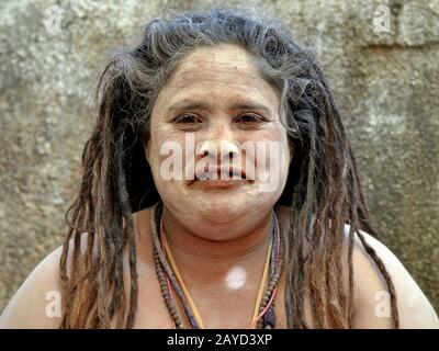 Chubby indiano indù femmina sadhu (sadhvi) con lunghi temadlock e sacro cenere (vibhuti) sul suo viso e spalle pone per la fotocamera. Foto Stock